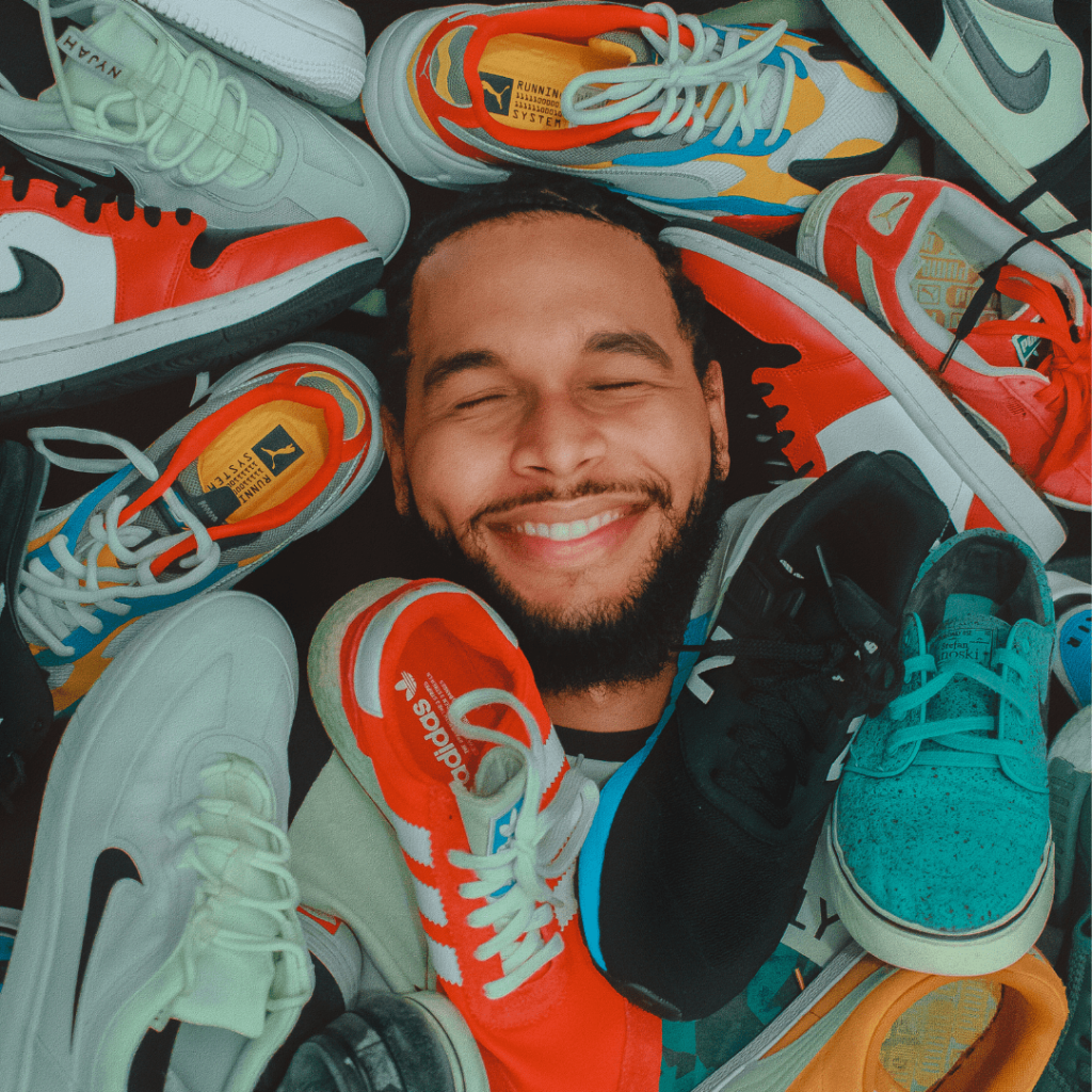 Man surrounded by Nike and Adidas Shoes.