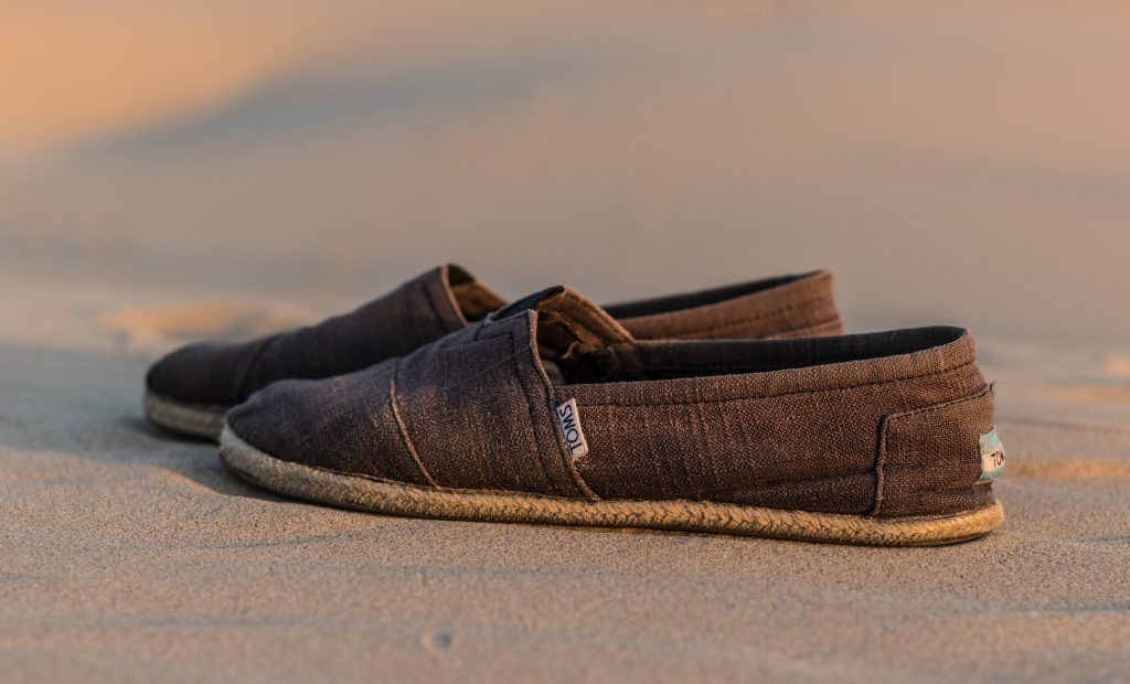 Pair of Toms shoes on the beach
