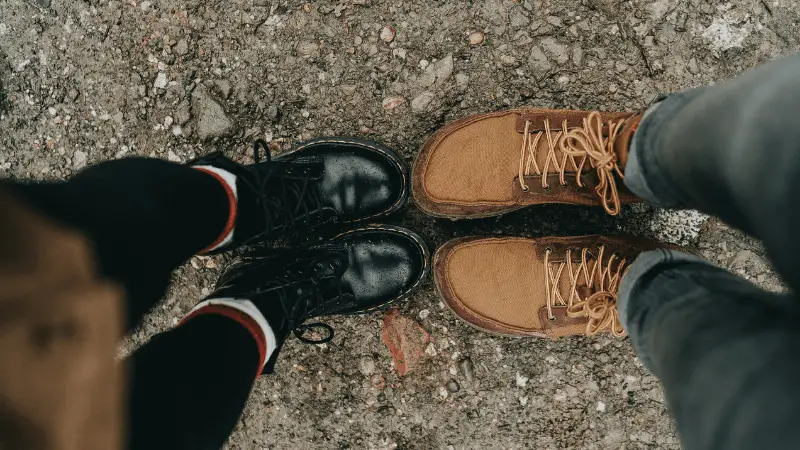 Pair of man and woman's boots facing each other.